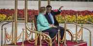 Bundeskanzlerin Angela Merkel und Chinas Ministerpräsident Li Keqiang sitzen auf einer Empore und unterhalten sich