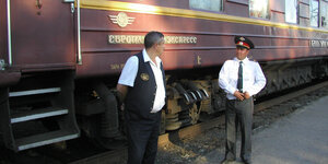 zwei Männer vor einem Zug der Transsibirischen Eisenbahn