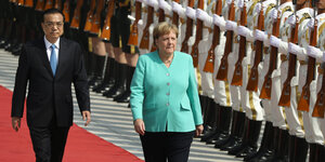 Der chinesische Premier Li Keqiang und Bundeskanzlerin Angela Merkel laufen an einer Reihe von Soldaten vorbei