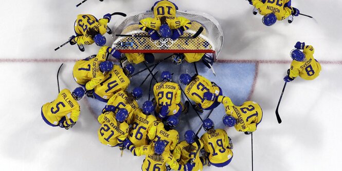 Viele Eishockeyspieler tummeln sich um ein Tor