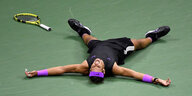 Tennisspieler Rafael Nadal liegt nach einem Punktgewinn auf dem Boden, den Schläger weit von sich entfernt.