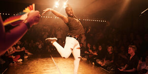 Ein Tänzer streckt seine Arme und Beine während eines Ballroom-Auftritts in Düsseldorf in die Luft.