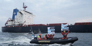 Greenpeace-Schlauchboot vor Kohleschiff aus Mosambik