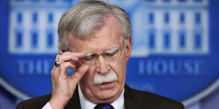 John Bolton fasst sich an die Brille