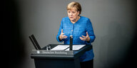 Bundeskanzlerin Angela Merkel steht an einem Rednerpult und spricht