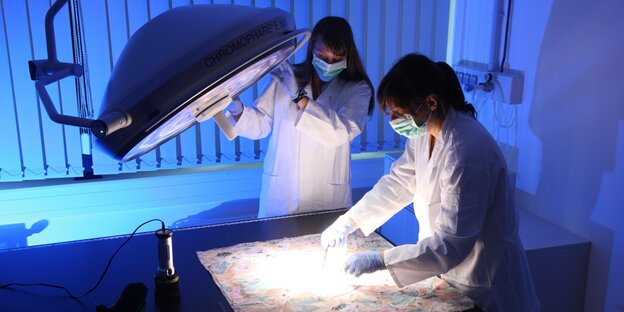 Im LKA wird ein Spurenträger von zwei Laborantinnen untersucht