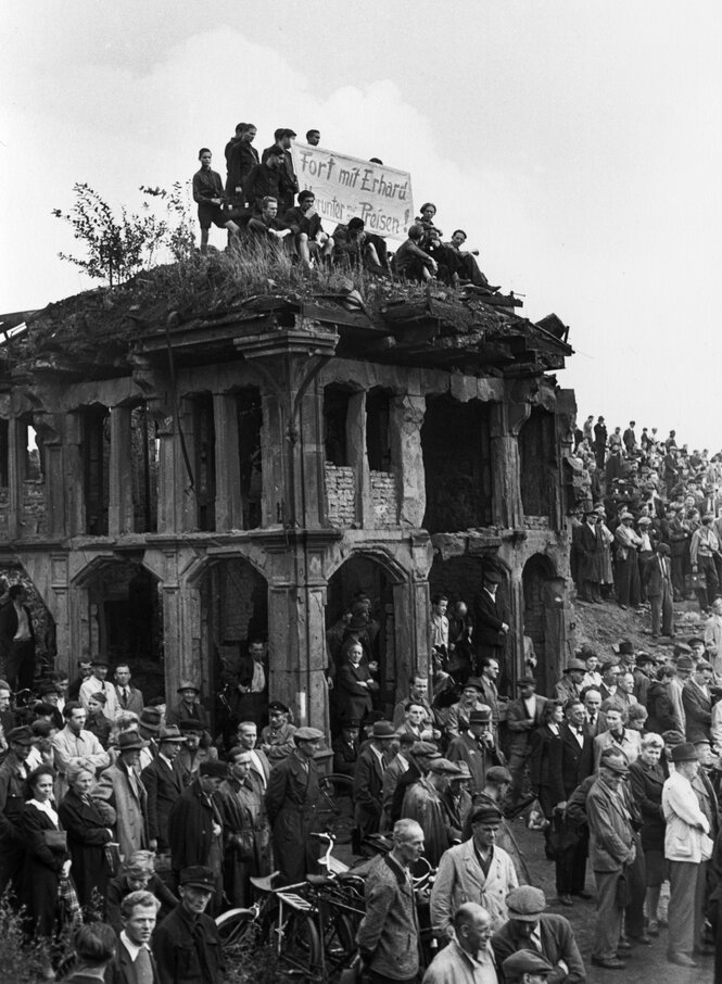 Viele streikende Menschen stehen um eine Ruine herum und sitzen auf ihr