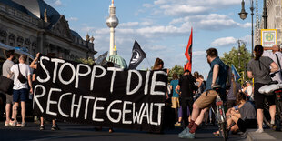 Protestierende in der Nähe des Fernsehturms halten ein Banner mit der Aufschrif "Stoppt die rechte Gewalt"