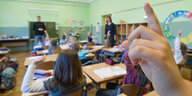 In einer Grundschule melden sich Kinder während des Unterrichts.