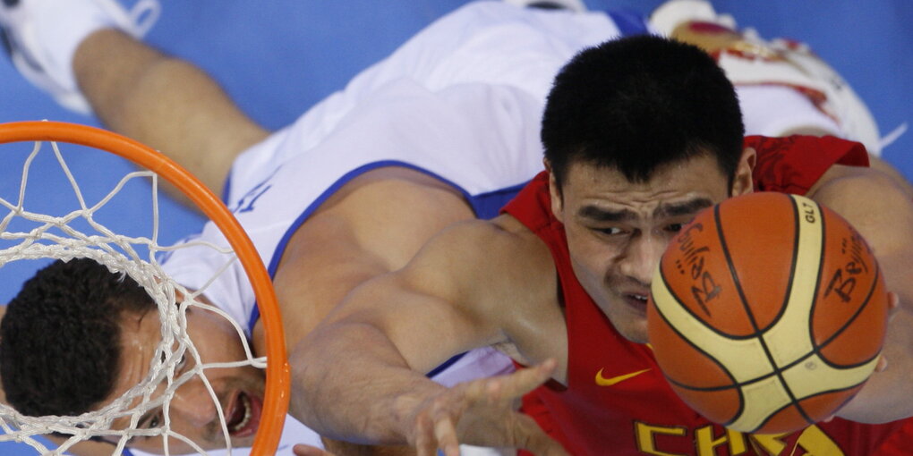 zwei Basketballer springen zum Korb