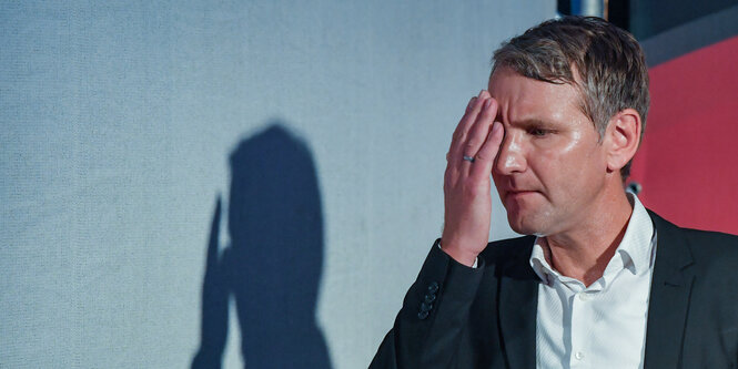 Björn Höcke hält die Hand vor sein Gesicht