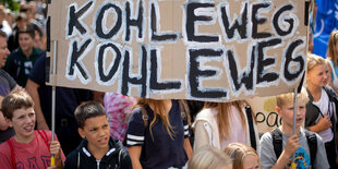 Teilnehmer der Klimademonstration "Fridays for Future" stehen mit ihrem Transparent mit der Aufschrift "kohle weg" im Invalidenpark