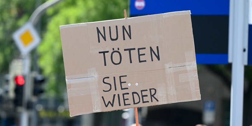 Auf einem Pappschild steht "Nun töten sie wieder".