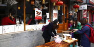 Drei Frauen machen Dumplings vor einem Restaurant in Beijing