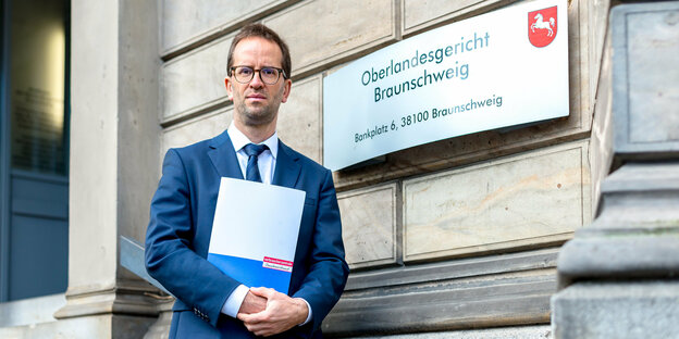 Verbraucherschützer Klaus Müller steht vor dem Schild des Oberlandesgerichts Braunschweig