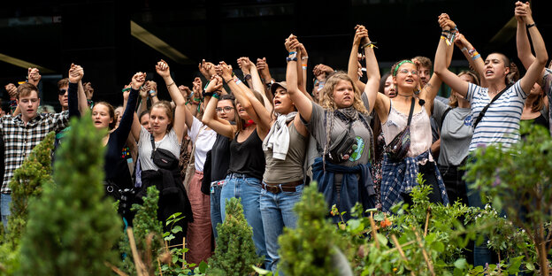 Junge Leute protestieren in Grünpflanzen
