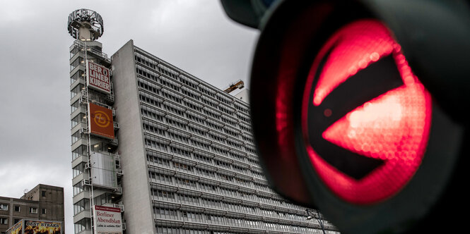 Eine Ampel steht auf "Rot", im Hintergrund ein Hochhaus