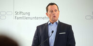 Richard Grenell, amerikanischer Botschafter in Deutschland hält eine Rede vor weißem Hintergrund