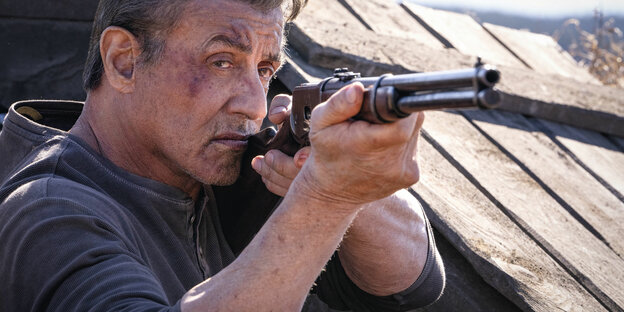 Ein Mann mit Gewehr, es ist Sylvester Stallone