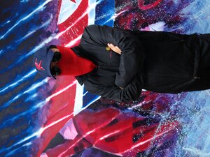 Der Künstler Sun Mu vor einem seiner Bilder mit einem Tuch vor dem Gesicht Der Künstler Sun Mu vor einem seiner Bilder mit einem Tuch vor dem Gesicht