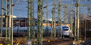 Ein ICE steht hinter zahllosen Oberleitungsmasten am Hauptbahnhof Leipzig