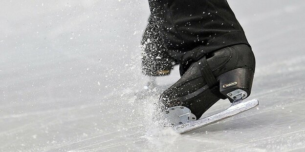 Schwarze Schlittschuhe fahren über das Eis Schwarze Schlittschuhe fahren über das Eis