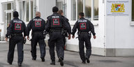Polizisten gehen auf dem Gelände der Außenstelle Stephansposching des Ankerzentrums Deggendorf