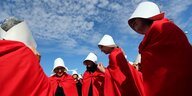 Aktivistinnen tragen rote lange Mäntel und weiße Kappen, die an die Frauen aus „Report der Magd“ erinnern sollen