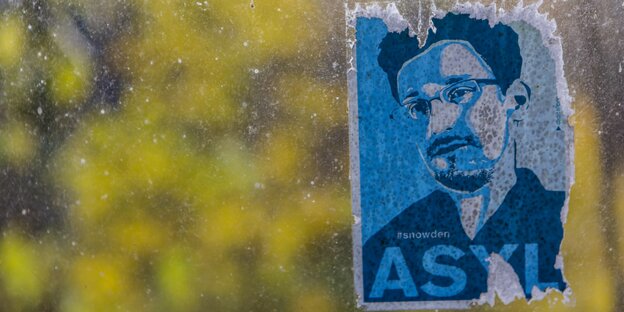 An einem Fenster klebt ein Sticker mit dem Gesicht Edward Snowdens, darunter steht das Wort „Asyl“