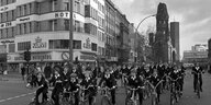 Schwarz-Weiß-Foto von radfahrenden Kindern auf einer breiten Straße