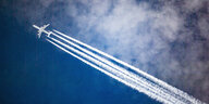 Ein Flugzeug mit Kondensstreifen am blauen Himmel