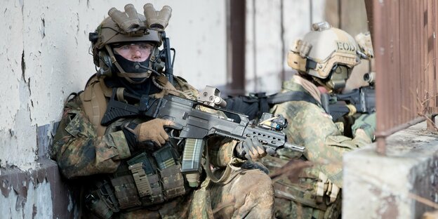Zwei Soldaten in Kampfmontur, einer mit Sturmgewehr