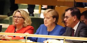 Umweltministerin Schulze, Kanzlerin Merkel und Entwicklungsminister Müller sitzen auf einer Bank im Sitzungssaal der Vereinten Nationen in New York