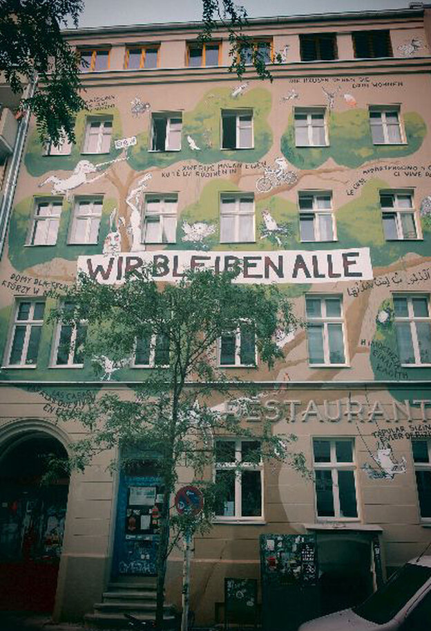Das sechsstöckige Haus an der Waldermarstraße mit einer bemalten Fassade. Die Malerei zeigt einen großen Baum, der sich um die Fenster schlängelt. Dazwischen sind Tiere gemalt. In der Mitte steht: 