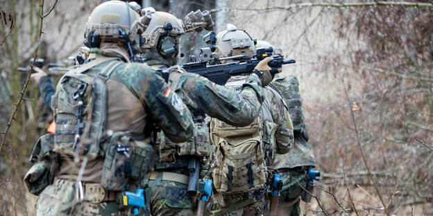 Soldaten im Training in Schutzkleidung und mit Waffen