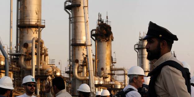Ein Sicherheitsbediensteter steht vor einer Öl-Raffinerie Wache