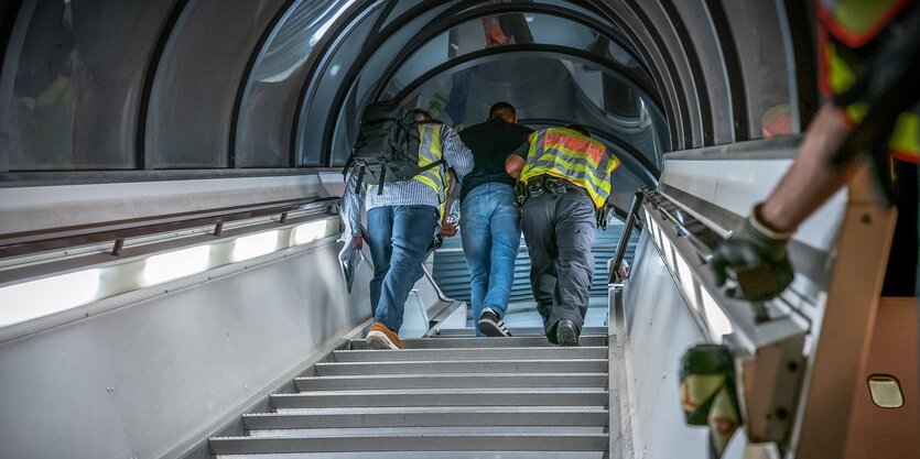 Zwei Beamte bringen einen Flüchling ins Flugzug - er wird abgeschoben