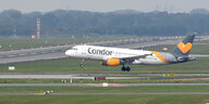 ein Flugzeug mit der Aufschrift Condor kurz nach dem Abheben auf der Startbahn eines Flughafens