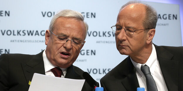 Die damaligen VW-Manager Martin Winterkorn und Herbert Diess blicken in ein Blatt Papier