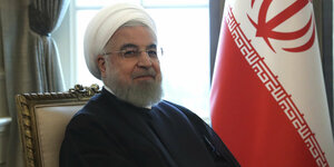 Hassan Ruhani sitzt in einem Sessel und schaut in die Kamera