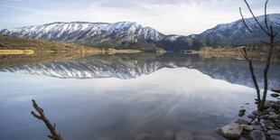 Berghügel spiegeln sich in einem See