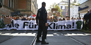 Ein Polizist steht in Bremen vor den Fridays for Future Demonstranten bei der großen Klimademo