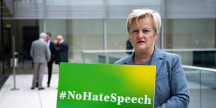 Renate Künast hält Plakat hoch, auf dem "#NoHateSpeech' steht