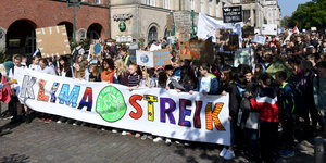 Mehrere junge Teilnehmer halten eine Banner auf einer Klimastreik-Demo in Kiel