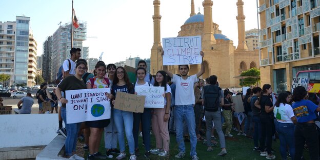 EIne Gruppe junger Menschen halten diverse Plakate hoch, darunter das Plakat "beirut Climate Strike"