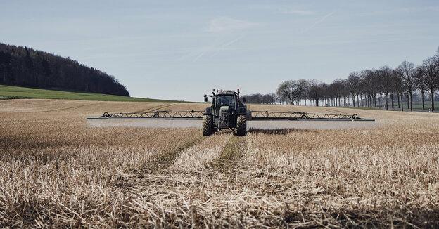 Ein Traktor bringt Glyphosat auf einem Feld aus