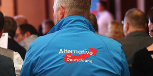 ein Mann trägt eine blaue Jacke mit dem AfD-Logo