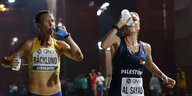 Zwei Marathonläuferinnen, schweißnass, trinken im Laufen Wasser
