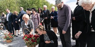 Menschen legen am Gedenkort Blumen nieder