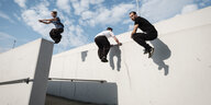 Parkour Training: junge Männer hüpfen von Mauer zu Mauer